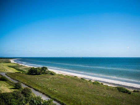 Blick aus dem Leuchtturm vereint ein Bild von Straße, Wiese, Strand und Wasser